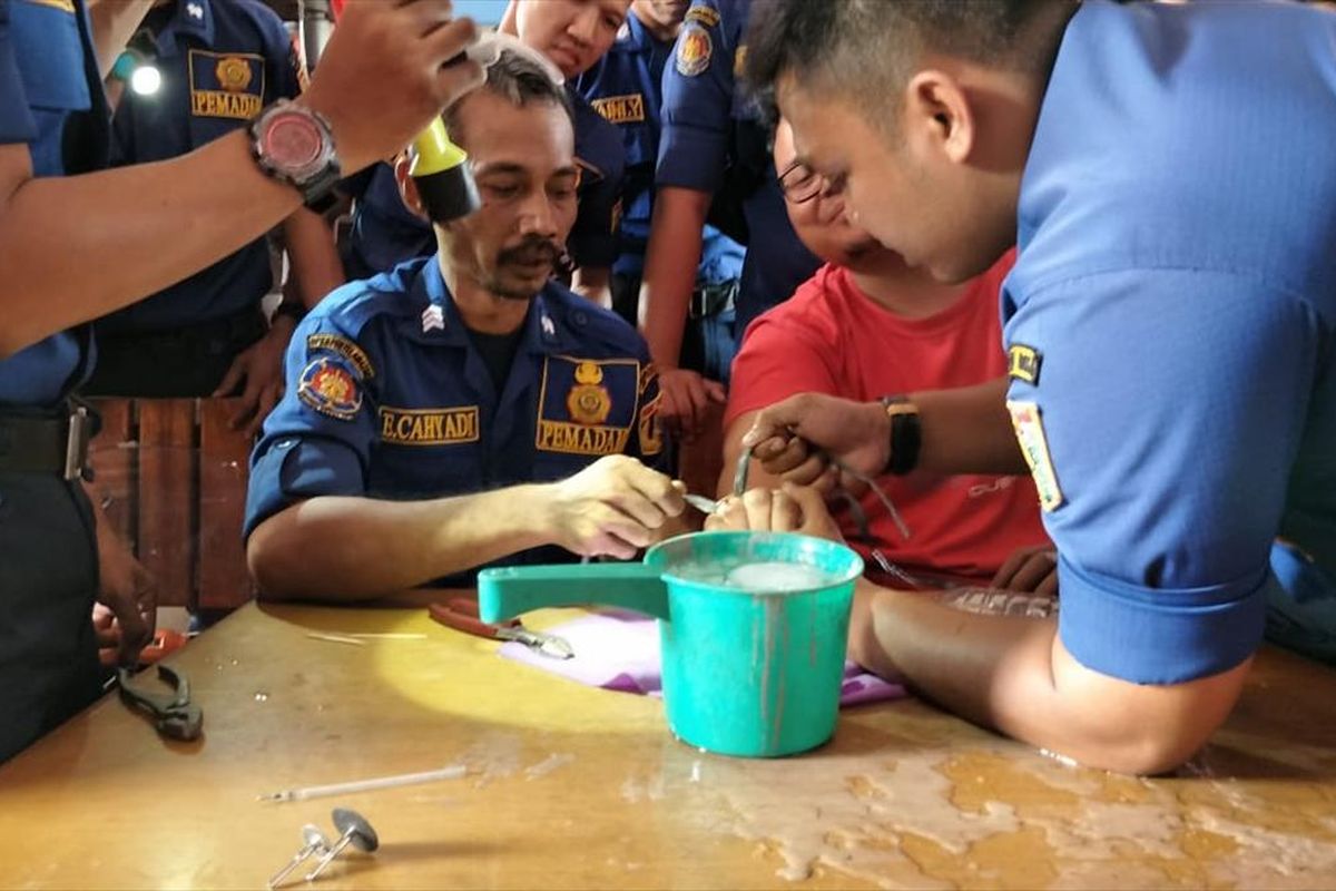 Petugas Sudin PKP Jakarta Timur bantu warga lepaskan cincin di jari di Markas Sudin PKP Jakarta Timur, Rabu (7/8/2019).