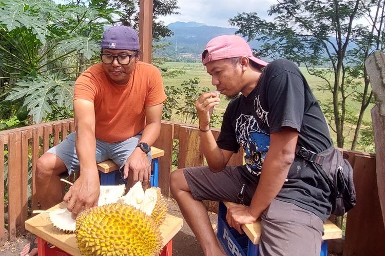 Pengunjung menikmati durian Brongkol sembari menikmati pemandangan perbukitan.