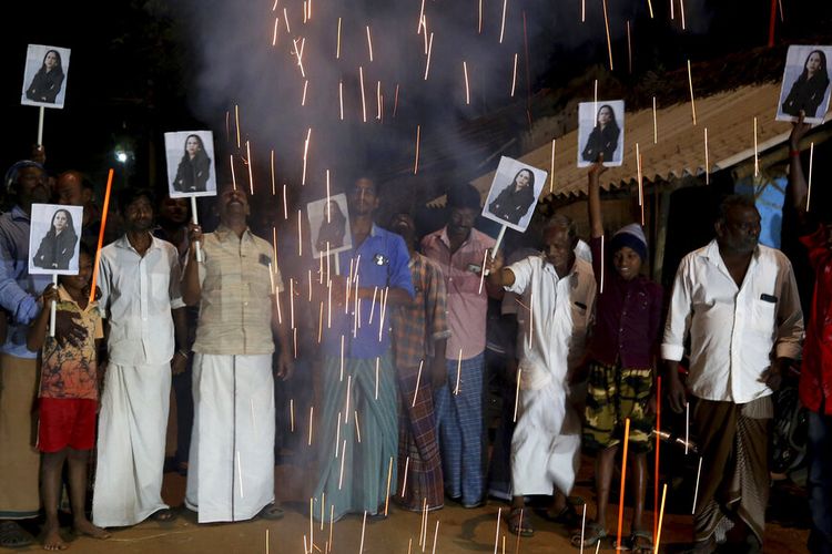 Penduduk desa melepaskan petasan dan memegang plakat yang menampilkan Wakil Presiden AS Kamala Harris setelah pelantikannya, di Thulasendrapuram Rabu (20/1/2021). 