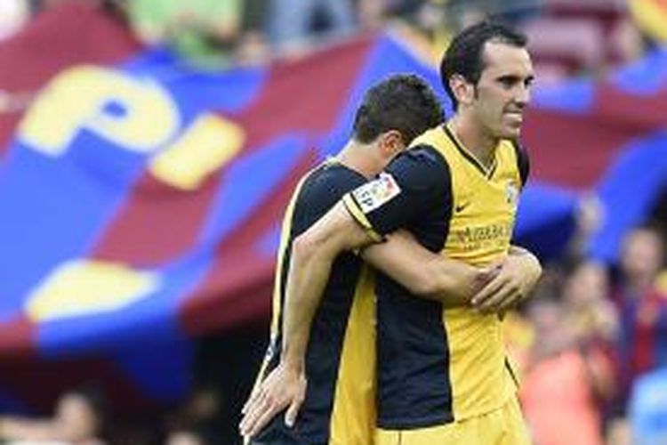 Gelandang Atletico Madrid, Koke (kiri) dan Diego Godin, merayakan gelar juara Primera Division seusai bermain imbang 1-1 dengan Barcelona di Stadion Camp Nou, Sabtu (17/4/2014). 