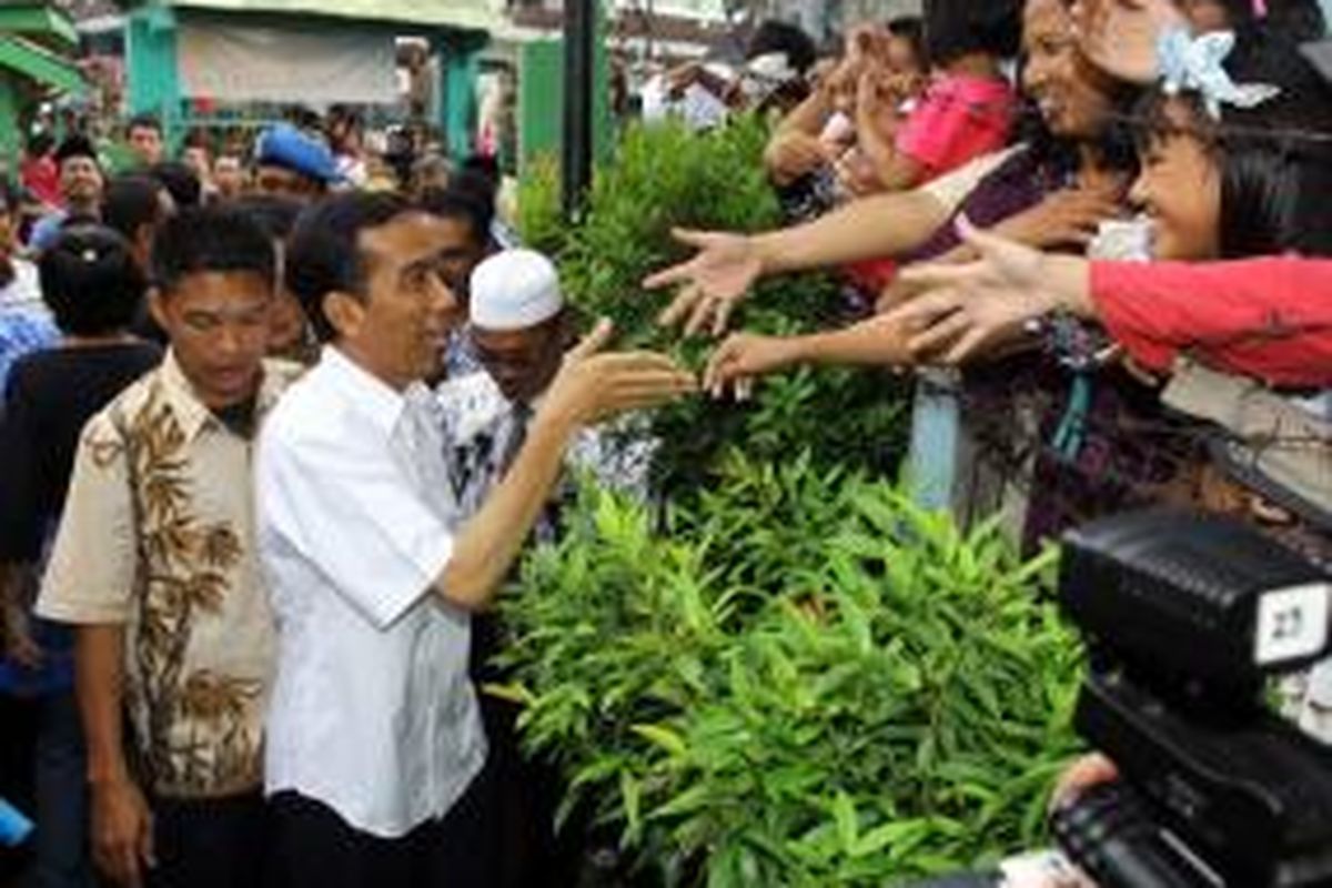 Gubernur DKI Jakarta Joko Widodo disambut warga yang berebut ingin bersalaman dengannya saat ia akan masuk ke SMP Negeri 108, Cengkareng, Jakarta Barat, Kamis (25/4/2013). Jokowi berkunjung ke SMPN 108 untuk bersilaturahim dan memberi arahan kepada siswa yang baru selesai melaksanakan Ujian Nasional (UN).