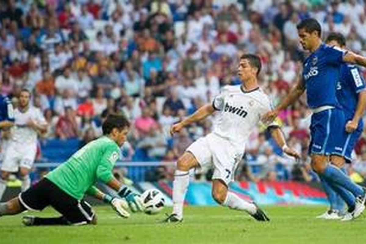 Kiper Valencia, Diego Alves, mengamankan bola dari kejaran gelandang Real Madrid, Cristiano Ronaldo, pada laga Liga BBVA, di Santiago Bernabeu, Minggu (19/8/2012).