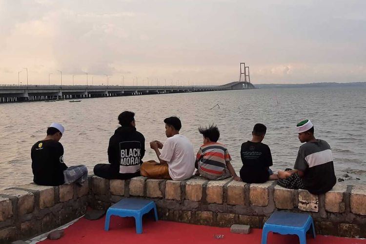 Warga ngabuburit di sekitar kaki jembatan Suramadu sisi Surabaya, Jumat (16/4/2021).