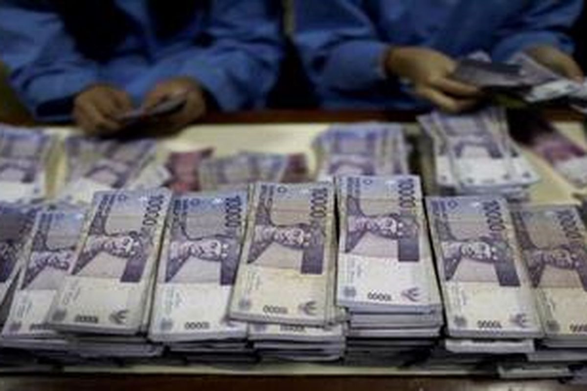 Petugas menyortir uang pecahan Rp. 10.000 di Sentra Operasi Kas (SOK) di kantor BRI Pusat di Jakarta, Rabu (28/3/2012). Rapat Umum Pemegang Saham Tahunan (RUPST) PT. Bank Rakyat Indonesia Tbk Tahun 2012 menetapkan pembagian dividen sebesar Rp3,02 triliun atau 20 persen dari total laba bersih pada 2011 sebesar Rp15,08 triliun.