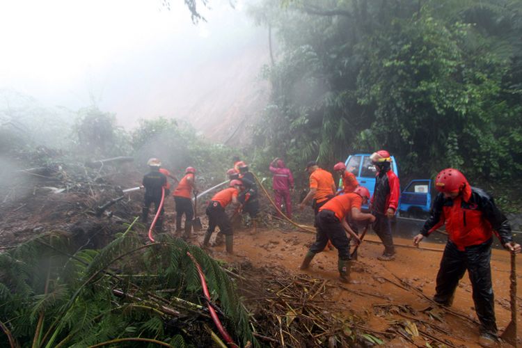 Petugas BPBD Kabupaten Bogor berusaha membersihkan material longsor yang menutupi jalur utama Puncak Bogor, Jawa Barat, Senin (5/2/2018). Jalur Puncak, Bogor ditutup sementara akibat cuaca ekstrem yang mengakibatkan bencana longsor di empat titik di ruas jalan di Jalan Raya Puncak yaitu di seputaran Masjid Attaawun, Riung Gunung, Grandhill, dan Widuri.