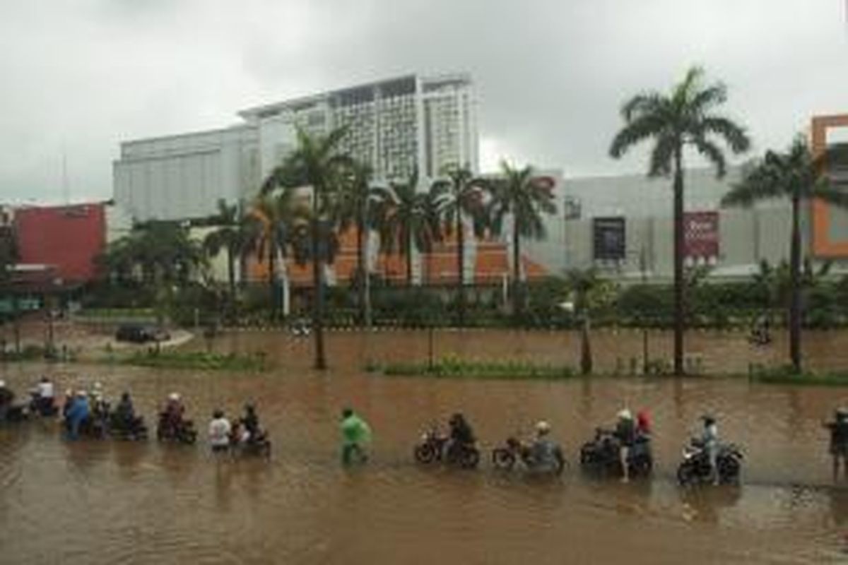Pengguna sepeda motor terhenti menunggu menyusutnya genangan air di Jalan Boulevard Raya, Kelapa Gading, Jakarta Utara, Jumat (18/1/2013).
