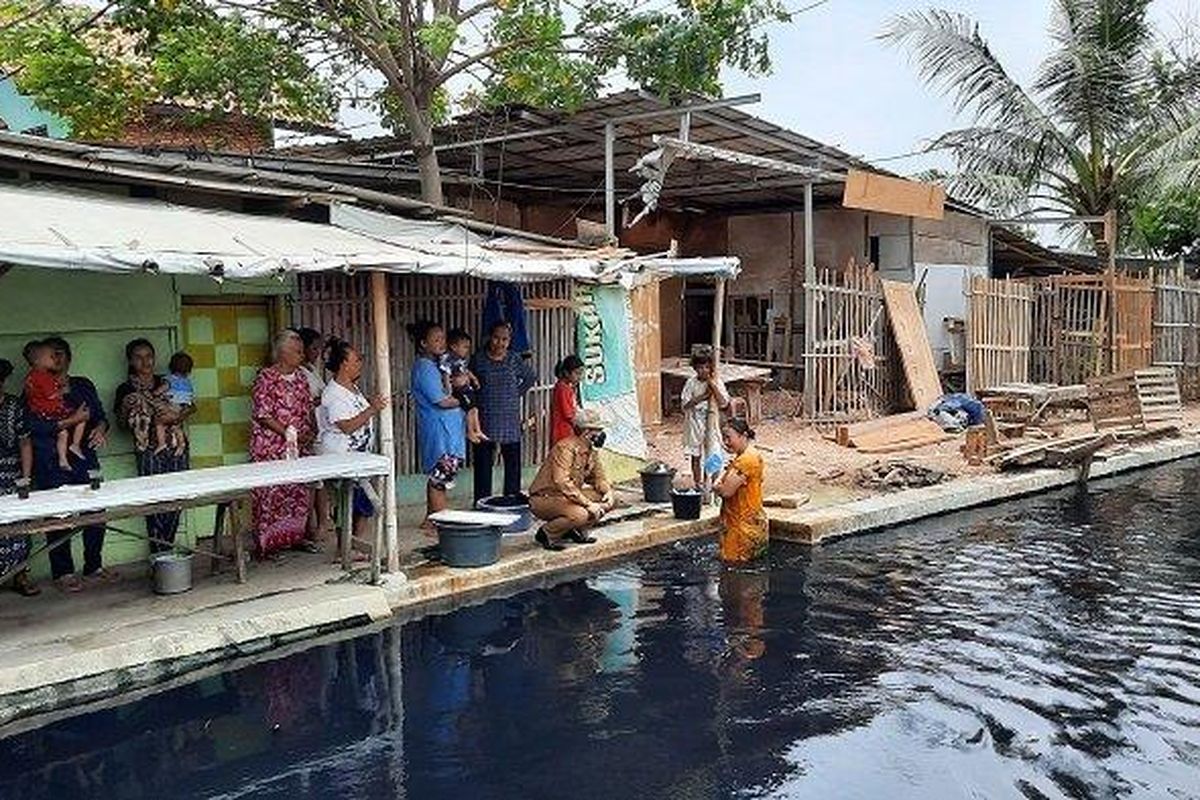 Pj Bupati Bekasi Dani Ramdan saat menghampiri warga yang sedang mandi di pinggir Kali Cilemahabang.