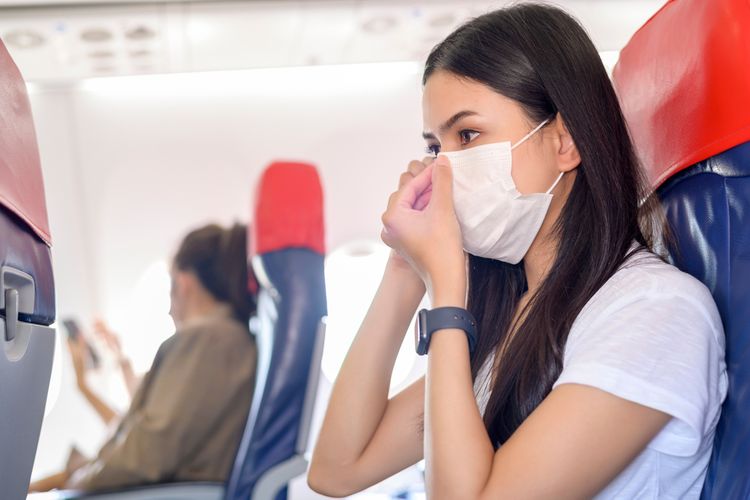 Ilustrasi penumpang pesawat memakai masker selama penerbangan.