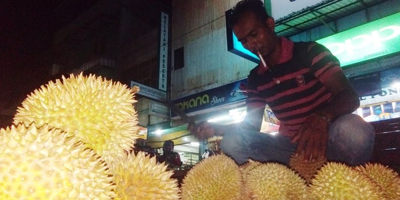 Pedagang memilihkan durian untuk pembeli di Jalan Perdagangan, Kota Lhokseumawe, Aceh, Sabtu (2/3/2019) malam.