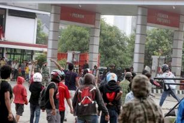 Sejumlah mahasiswa Universitas Muhammadiyah Makassar melempar batu ke arah SPBU saat terjadi kerusuhan dengan warga di Jalan Sultan Alauddin, Makassar, Sulawesi Selatan, Selasa (18/11/2014). Kerusuhan tersebut disebabkan warga marah karena mahasiswa menutup jalan saat berunjuk rasa memprotes kenaikan harga bahan bakar minyak.