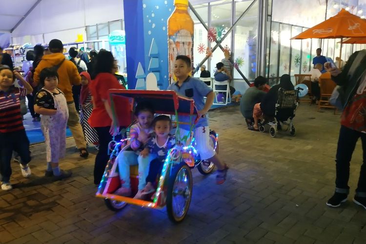 Anak-anak menjajal becak di Pekan Raya Jakarta, Jumat (7/6/2019).