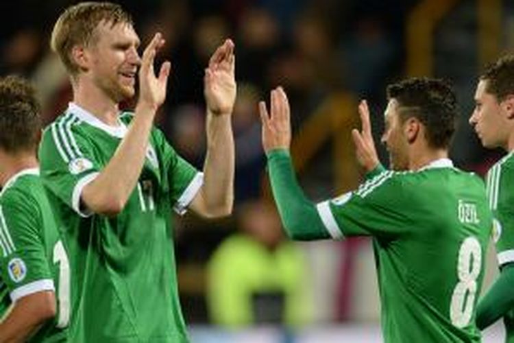 Gelandang Jerman, Mesut Oezil (kanan) dan bek Jerman Per Mertesacker merayakan gol yang dicetak ke gawang Kepulauan Faroe pada laga kualifikasi Piala Dunia 2014, Selasa (10/9/2013) di Torshavn. Jerman menang 3-0.