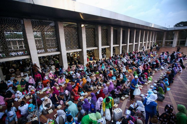 Warga berbuka puasa bersama di Masjid Istiqlal, Jakarta Pusat, Jumat (18/5/2018). Pengurus Masjid Istiqlal setiap hari menyiapkan 4.000 nasi bungkus dan takjil untuk berbuka puasa selama Ramadhan.