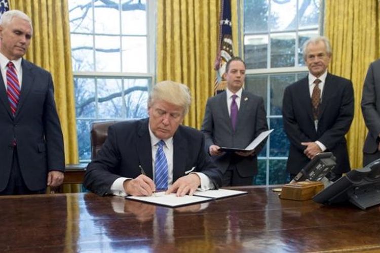 Presiden AS Donald Trump menandatangani sejumlah perintah eksekutif di ruang Oval, Gedung Putih disaksikan wakil presiden Mike Pence, kepala staf Gedung Putih Reince Preibus, dan penasihat senior Jared Kushner.