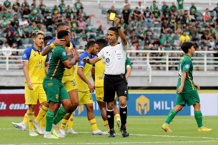 Wasit Thoriq Alkatiri memberi kartu kuning kepada pemain Persebaya Surabaya saat pertandingan pekan ke-2 Liga 1 2023-2024 melawan Barito Putera yang berakhir dengan skor 1-1 di Stadion Gelora Bung Tomo Surabaya, Sabtu (8/7/2023) sore. 