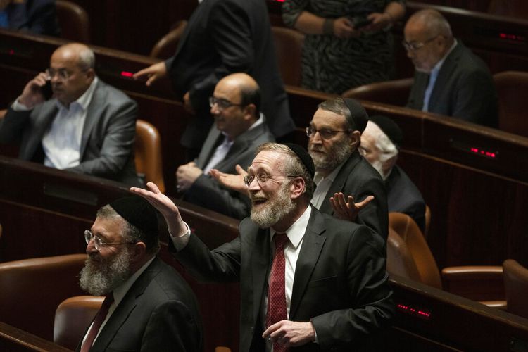 Anggota parlemen merayakan kekalahan undang-undang tentang status hukum pemukim Yahudi di Tepi Barat yang diduduki, selama sesi Knesset, parlemen Israel, di Yerusalem, Senin, 6 Juni 2022.