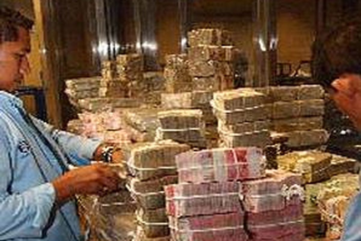 Dua orang kasir di Bagian Pengelolaan Uang Keluar Bank Indonesia (BI), Jakarta, sedang menghitung tumpukan uang yang akan diserahkan ke bank-bank umum.