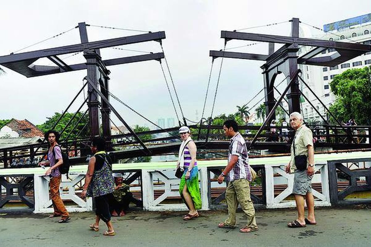 Wisatawan mancanegara menikmati pemandangan di Jembatan Kota Intan di kawasan Kota Tua, Jakarta, Jumat (18/5). Pariwisata menjadi salah satu sektor yang  menggerakkan ekonomi dunia. Kementerian Pariwisata dan Ekonomi Kreatif menargetkan kunjungan wisatawan mancanegara 12 juta orang tahun 2012. 