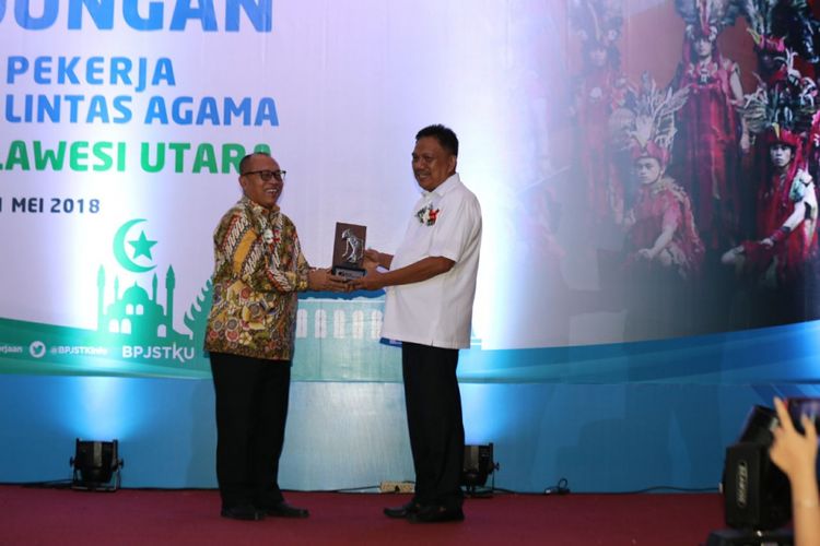 Direktur Utama BPJS Ketenagakerjaan, Agus Susanto (kiri) bersama Gubernur Sulawesi Utara, Olly Dondokambey (kanan). Pemerintah Provinsi Sulawesi Utara memecahkan rekor MURI pemberian jaminan sosial ketenagakerjaan untuk pekerja lintas agama terbanyak di Indonesia, Jumat (11/5/2018). 