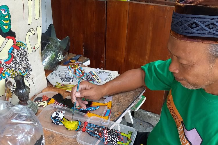 Iskandar saat memotong mengecat Wayang Uwuh yang terbuat dari Plastik, Jumat (13/1/2023)