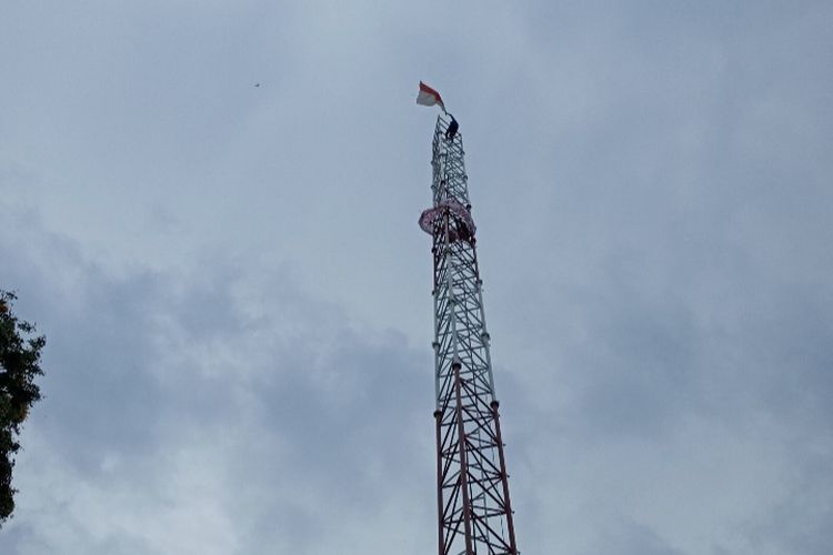 Foto: Agustinus Woro (53) membentangkan merah putih di atas puncak tower setinggi 43 meter yang terletak di Jalan Don Tomas Kelurahan Kota Baru, Kecamatan Alok Timur, Kabupaten Sikka, NTT, Selasa (8/11/2022).