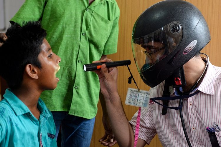 Dokter di India memeriksa pasien sambil mengenakan helm, sebagai bentuk kritik dan protes akan kurangnya keamanan tenaga medis yang kerap mendapat kekerasan dari pasien dan keluarga pasien.