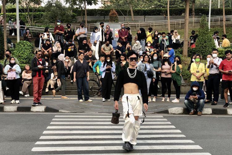 Vincent, remaja SCBD di Citayam Fashion Week berjalan bak model di zebra cross kawasan Stasiun MRT Dukuh Atas, Sudirman, Jakarta, Rabu (20/7/2022). Citayam Fashion Week menginspirasi banyak aktivitas serupa di berbagai kota.