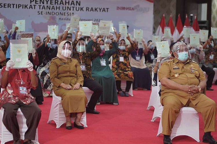 Gubernur Sulawesi Tenggara Ali Mazi (kanan) bersama perwakilan warga saat penyerahan sertifikat tanah gratis untuk rakyat se-Indonesia, di Rujab Gubernur Sulawesi Tenggara, Kendari, Sulawesi Tenggara, Selasa (5/1/2021). Presiden RI Joko Widodo secara virtual menyerahkan sertifikat tanah gratis untuk rakyat se-Indonesia, untuk di Sulawesi Tenggara sebanyak 26.542 lembar sertfikat yang tersebar di 17 kabupaten/kota.