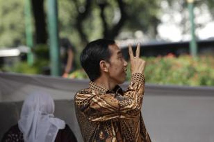 Calon Presiden nomor urut 2, Joko Widodo, didampingi istrinya Iriana Widodo menunjukkan salam dua jari seusai memberikan suara di TPS 18, Taman Suropati, Jakarta, Rabu (9/7/2014). Hari ini rakyat Indonesia melaksanakan pemilihan umum untuk memilih presiden dan wakil presiden. KOMPAS IMAGES/RODERICK ADRIAN MOZES