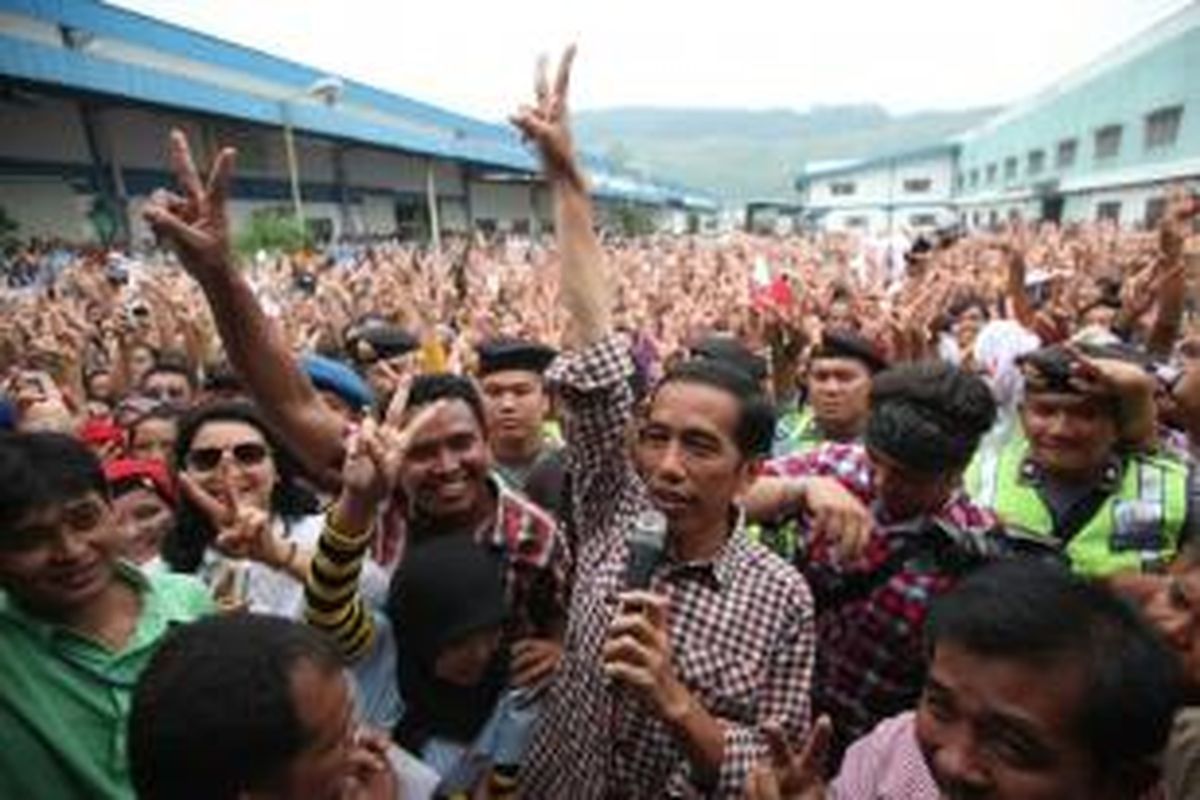 Bersama ribuan buruh, capres nomor urut 2, Joko Widodo (Jokowi), mengacungkan salam dua jari usai berorasi di halaman pabrik di Kawasan Berikat PT Daehan Global, Cibadak, Sukabumi, Jawa Barat, Rabu (2/7/2014). Dalam kesempatan itu, Jokowi mengajak buruh untuk selalu mengutamakan musyawarah dengan pengusaha untuk menyelesaikan berbagai masalah perburuhan.