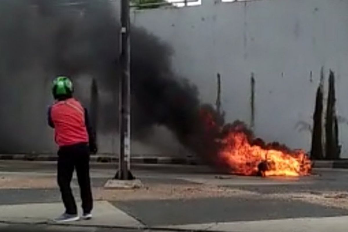 Pengendara ojek online mengambil video peristiwa motor terbakar di Terowongan Pasar Gembrong, Kecamatan Jatinegara, Jakarta Timur, Senin (9/3/2020). 