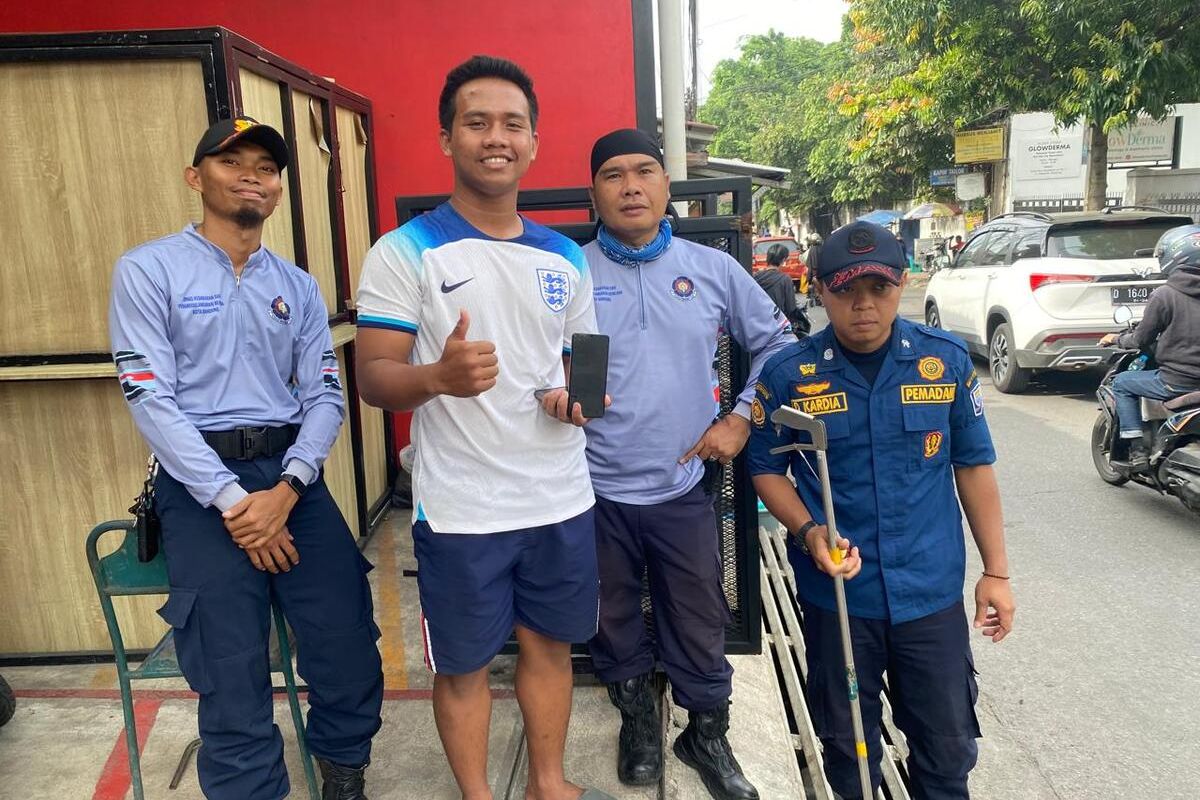 Petugas berhasil mengambik ponsel warga yang jatuh masuk ke saluran air.