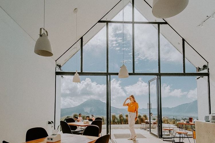Area indoor yang populer sebagai spot foto Instagramable dengan dinding dari kaca dan pemandangan langsung ke arah gunung