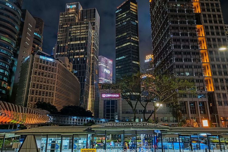 Halte Gelora Bung Karno dan bangunan perkantoran di Senayan, Jakarta, Senin, (14/2/2022). Pengambilan gambar diambil dengan smartphone Realme 9 Pro+ Mode Night