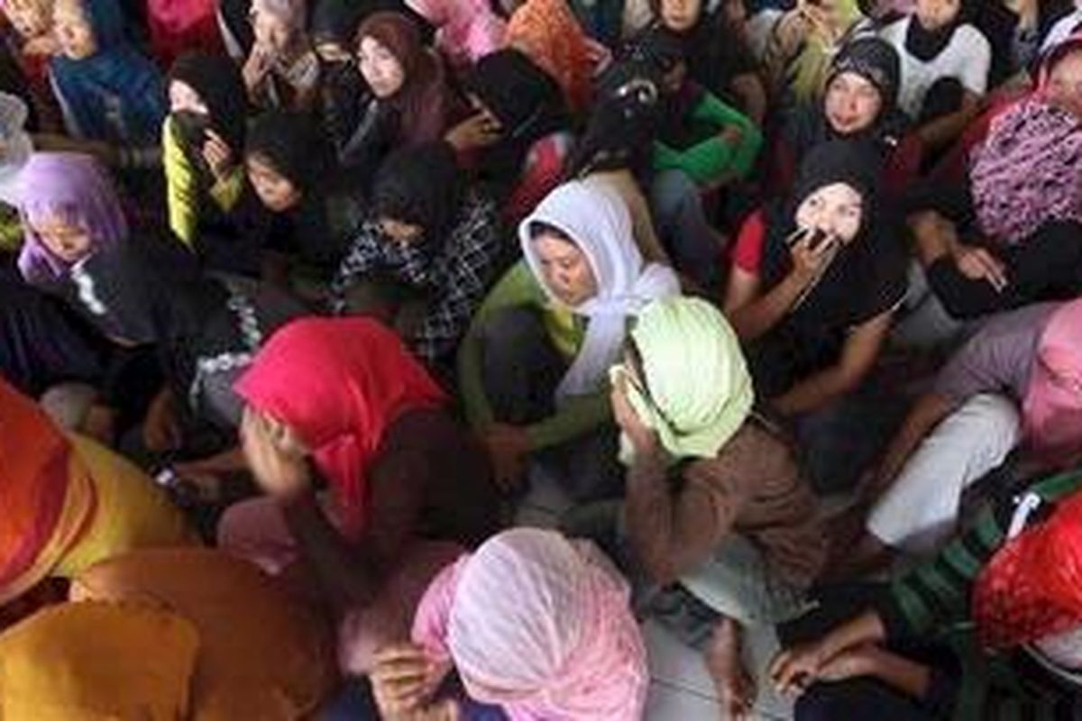 Calon tenaga kerja Indonesia (TKI) dari PT Duta Tangguh Selaras di Kelurahan Jatiasih, Bekasi, Jawa Barat, dikumpulkan setelah Direskrimsus Polda Metro Jaya menggrebek tempat penampungan tersebut, Rabu (22/6/2011). Dari tempat tersebut polisi menemukan 250 TKI yang 12 di antaranya diduga bermasalah karena kurang umur, hamil, dan buta huruf.