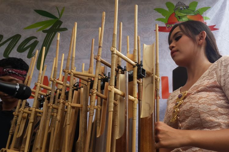 Salah satu instruktur untuk mengajarai bermain angklung bagi pengunjung yang disiapkan oleh pengelola Predator Fun Park, Kota Batu, Jawa Timur, Kamis (16/11/2017)