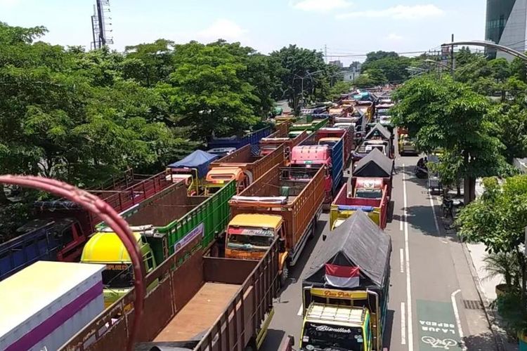 Ribuan sopir truk beserta kendaraannya memadati Jalan Frontage A. Yani, Surabaya, Jawa Timur, tepatnya di depan Kantor Dinas Perhubungan Jatim, untuk melakukan aksi demonstrasi menolak aturan ODOL, Selasa (22/2/2022).