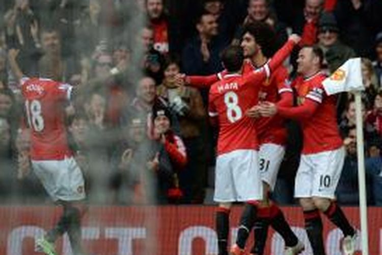 Pemain Manchester United, Maroune Fellaini, merayakan golnya bersama rekan-rekannya seusai mencetak gol ke gawang Tottenham Hotspur, Minggu (15/3/2015). 