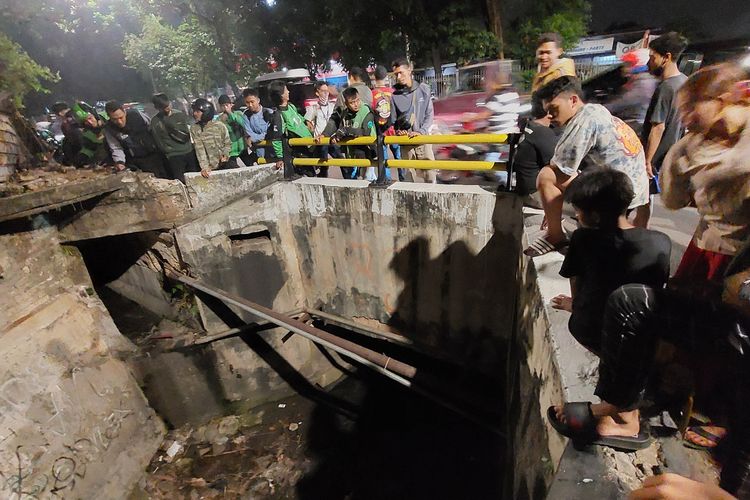 Warga tengah melihat lokasi seorang penjambret ponsel yang melarikan diri dari kejaran warga hingga masuk ke gorong-gorong di Jalan Panjang, Kebon Jeruk, Jakarta Barat, pada Selasa (30/8/2022) malam.