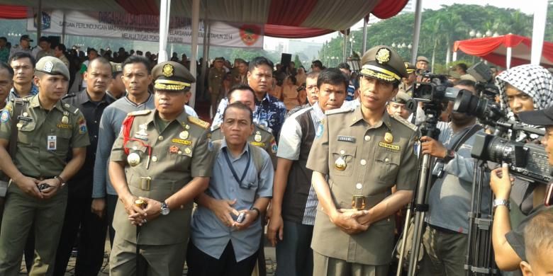 Gubernur DKI Jakarta Joko Widodo (kanan) bersama dengan Kepala Satpol PP DKI Jakarta Kukuh Hadi Santoso (kiri), saat acara peringatan HUT Satpol PP DKI Jakarta ke-64, di Tugu Monas, Jakarta, Kamis (27/3/2014)