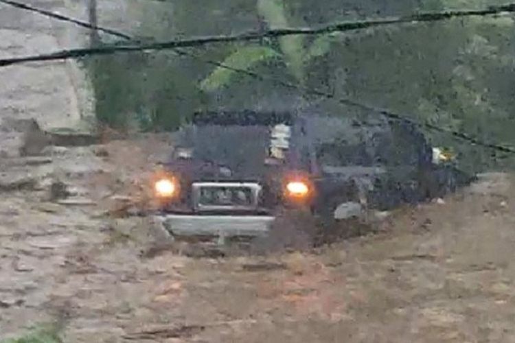 Suasana saat banjir bandang yang terjadi di Kecamatan Cicurug, Kabupaten Sukabumi, Jabar, Senin (21/9/2020). Tampak sebuah mobil terseret arus dan dua orang terbawa hanyut air sungai yang meluap. 
