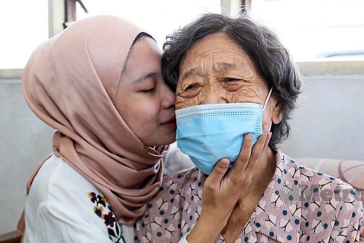 Rohana Abdullah memeluk dan mencium ibu angkatnya, Chee Hoi Lan, 83. 