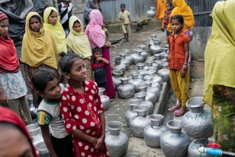 Perempuan dan anak-anak Rohingya mengantre untuk mendapatkan air di kamp-kamp pengungsi di Teknaf, Banglades, pada Desember 2016. Ribuan warga Rohingya mengungsi dari Rakhine, Myanmar, diduga akibat kekerasan aparat keamanan setempat.