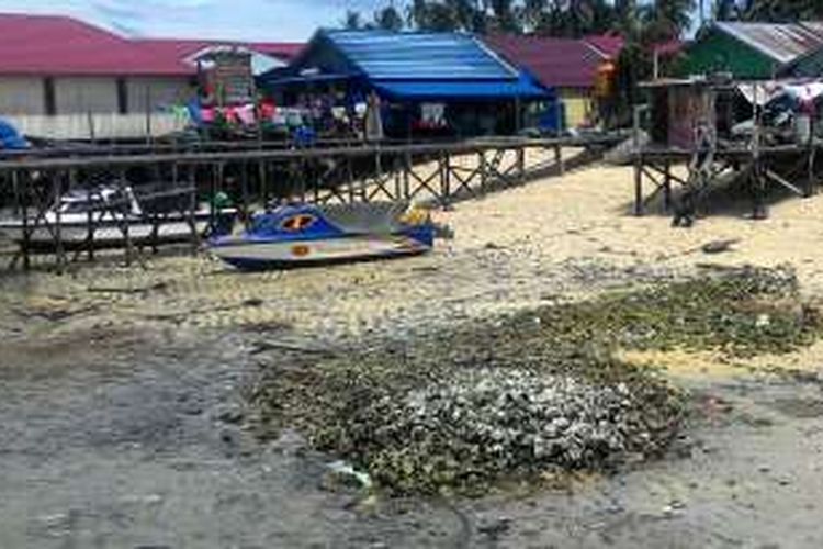 Limbah rumah tangga ditumpuk begitu saja di tepi pantai di belakang rumah di Pulau Derawan, Kalimantan Timur.