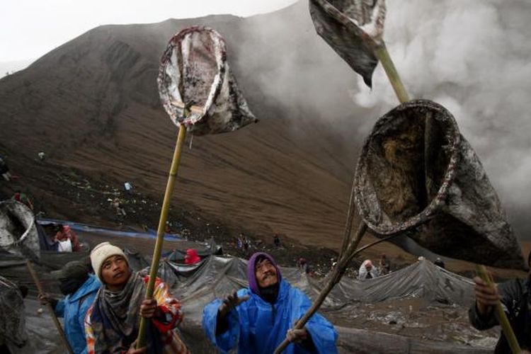 Beberapa warga Suku Tengger mencoba menangkap sesaji yang dilemparkan ke dalam Kawah Bromo oleh penganut Hindu Tengger, saat Yadnya Kasada digelar pada 20-21 Juli 2016.