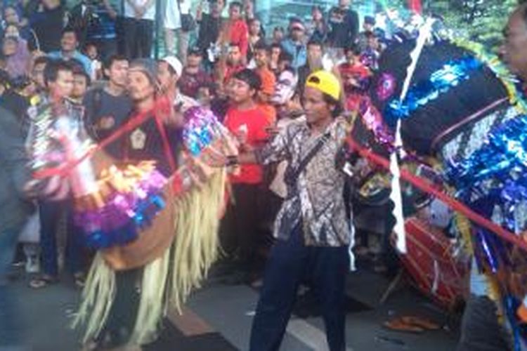 Sekelompok masyarakat melakukan atraksi kuda lumping di pelataran gedung KPK, Senin (16/2/2015).