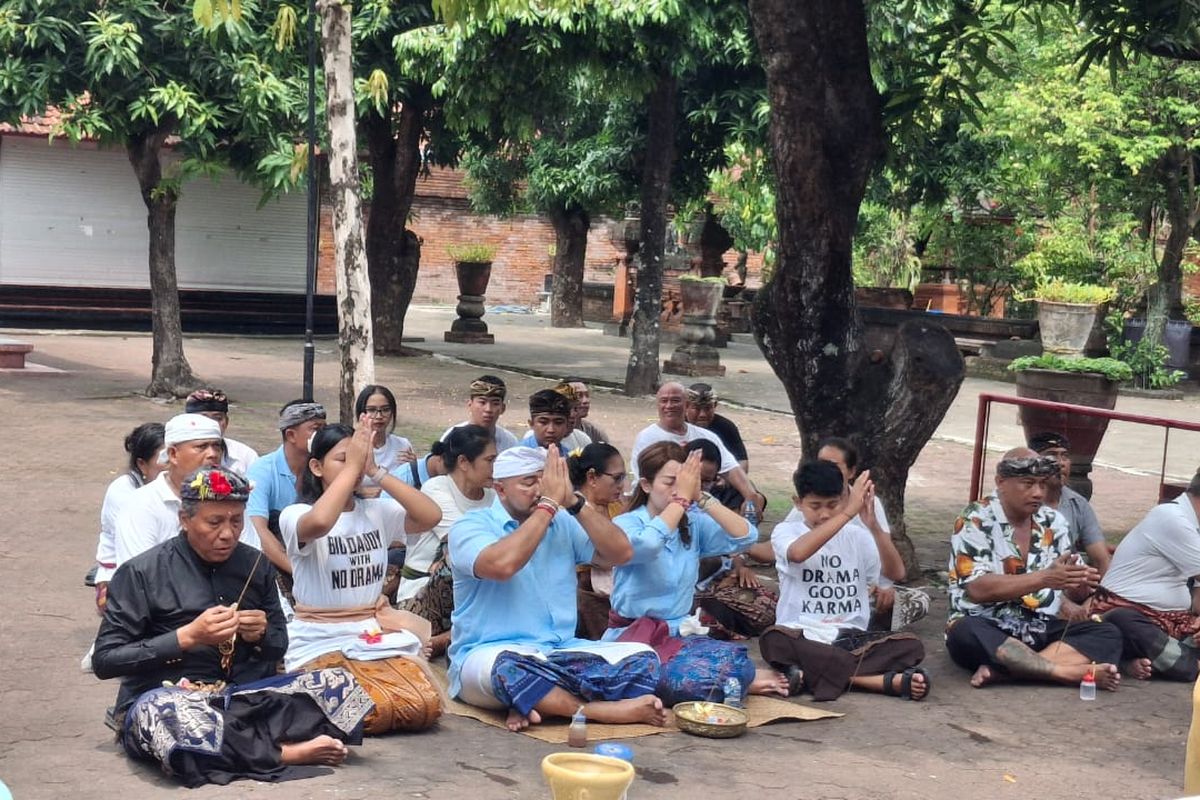 Calon Gubernur Bali nomor urut 1, Made Muliawan Arya alias De Gadjah bersama keluarga saat bersembahyang sebelum mencoblos di Tempat Pemungutan Suara (TPS) 12 Jalan Gunung Batur, Pemecutan, Kota Denpasar, Bali, pada Rabu (27/11/2024). KOMPAS.com/ Yohanes Valdi Seriang Ginta