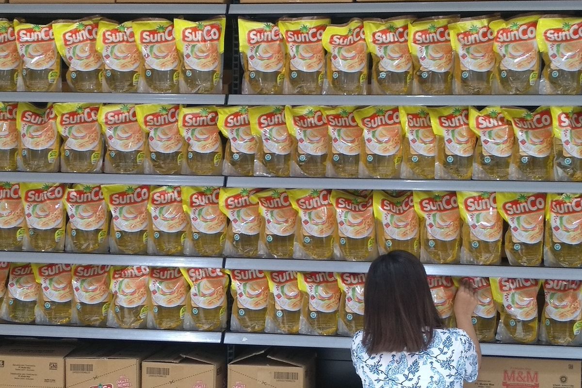 Seorang pekerja menyusun minyak goreng kemasan di sebuah supermarket yang kini memberlakukan harga baru, Rp 44.900 per 2 liter dari sebelumnya, Rp 28.000 per 2 liter.