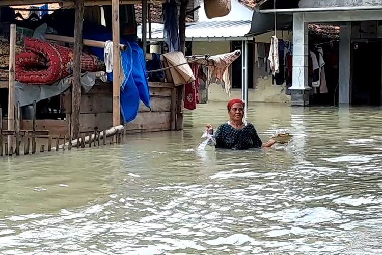 Warga Desa Cangkring Pos, Kecapean Karanganyar menerjang banjir Demak, Minggu (17/3/202)