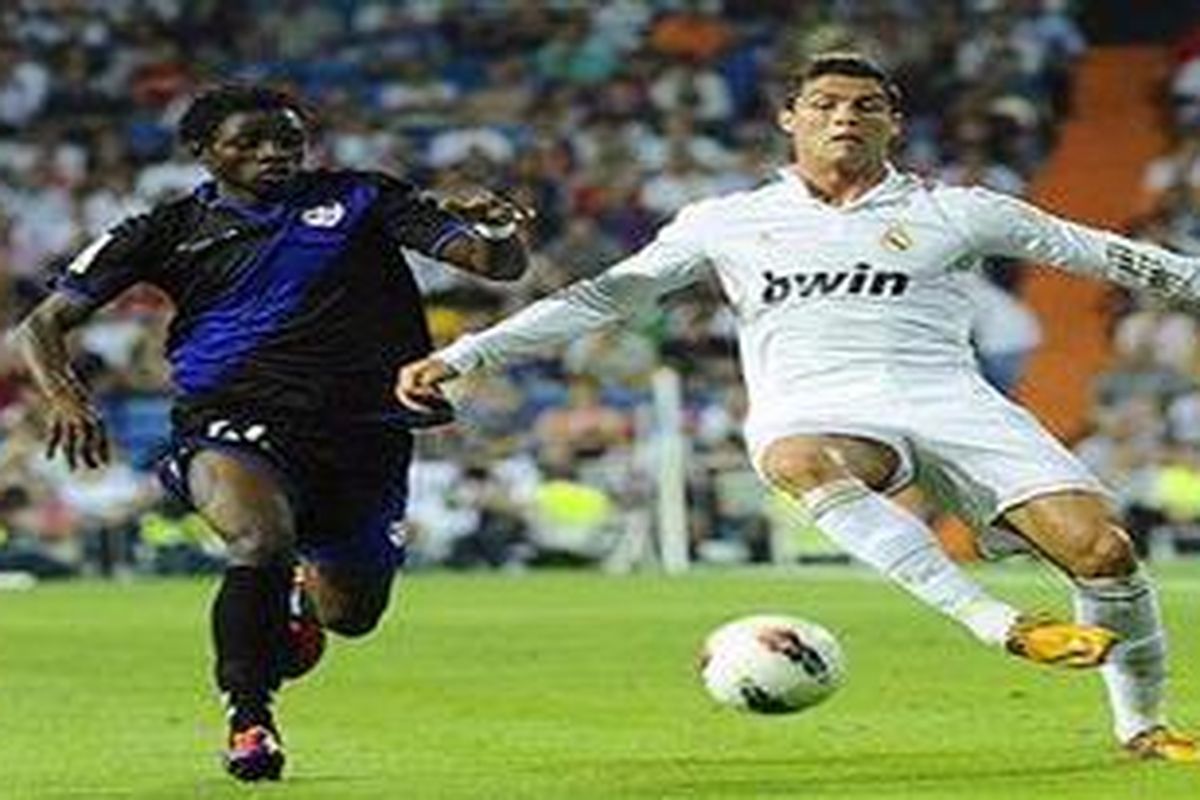 Penyerang Real Madrid, Cristiano Ronaldo (kanan) dikawal pemain Rayo Valecano, Lass, pada lanjutan Liga BBVA, Sabtu atau Minggu (25/9/2011) dini hari WIB. Ronaldo mencetak tiga gol dan Madrid akhirnya menang 6-2.
